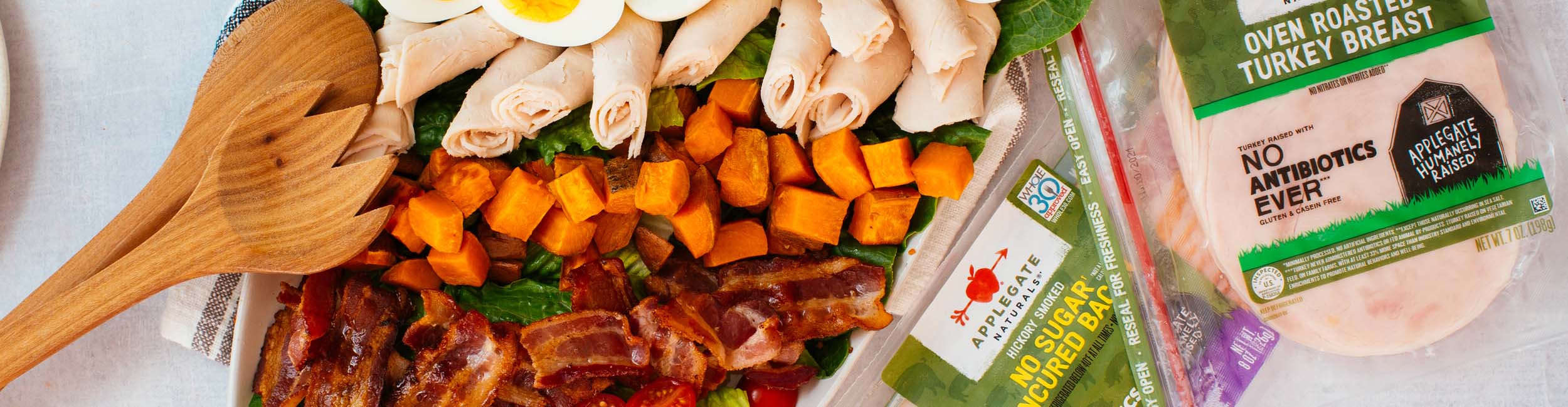 A colorful plate of vegetables and Applegate bacon and turkey slices.