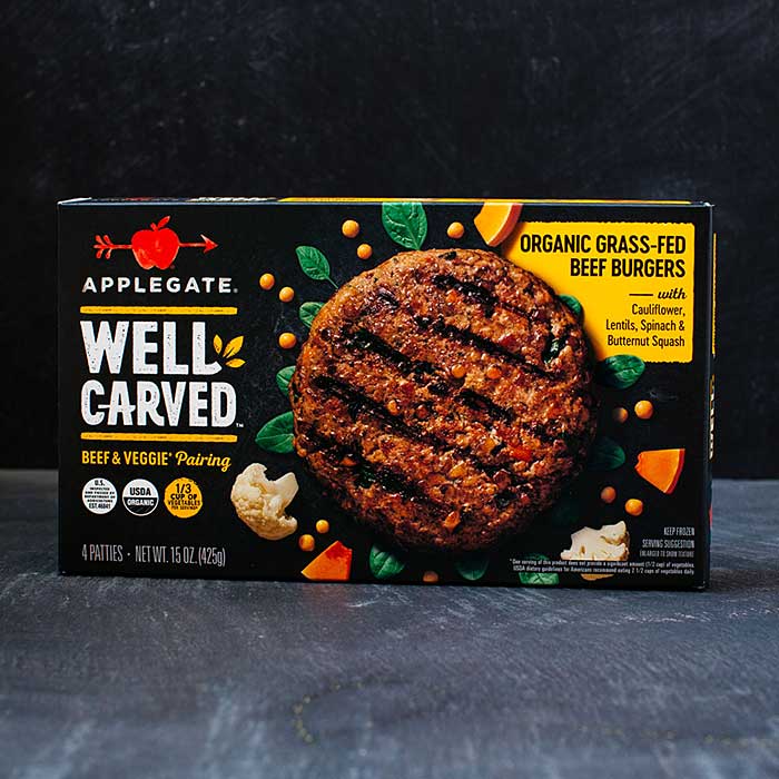 Applegate Well Carved organic grass-fed beef burger package featuring a grilled beef patty with vegetables on a dark background